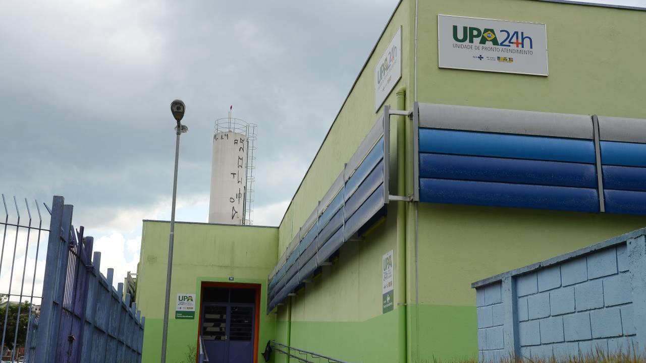 uma unidade de pronto atendimento. local de concreto com um pouco de grama na frente e um portão na lateral.