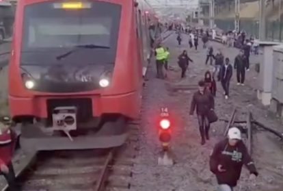 um trem parado e pessoas andando pelos trilhos