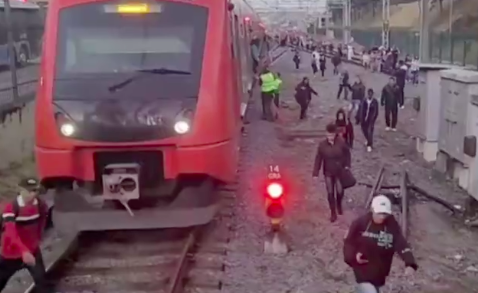 um trem parado e pessoas andando pelos trilhos