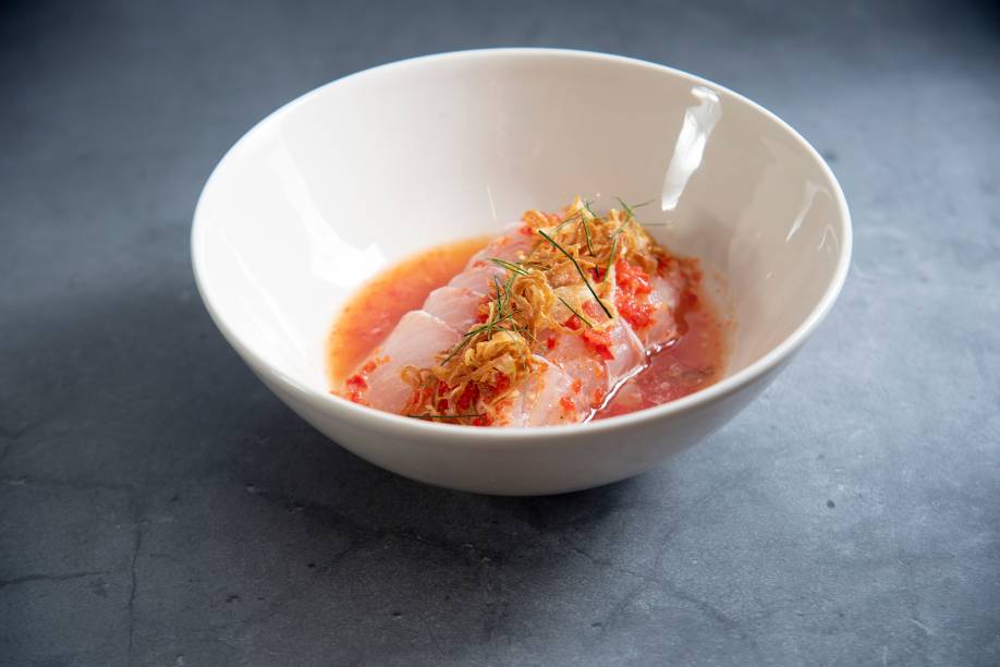 Pla dip: fatias de peixe cru ao nahm jim salpicadas de chips de chalota e folhas de limão kaffir Pla dip: fatias de peixe cru ao nahm jim salpicadas de chips de chalota e folhas de limão kaffir