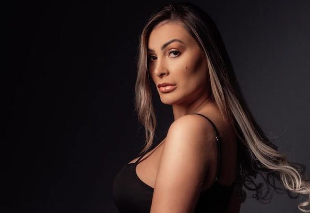 uma mulher de cabelos compridos, lisos e loiros olhando para a câmera