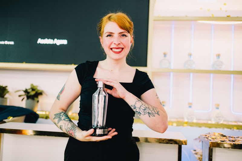Mulher segura troféu em forma de coqueteleira