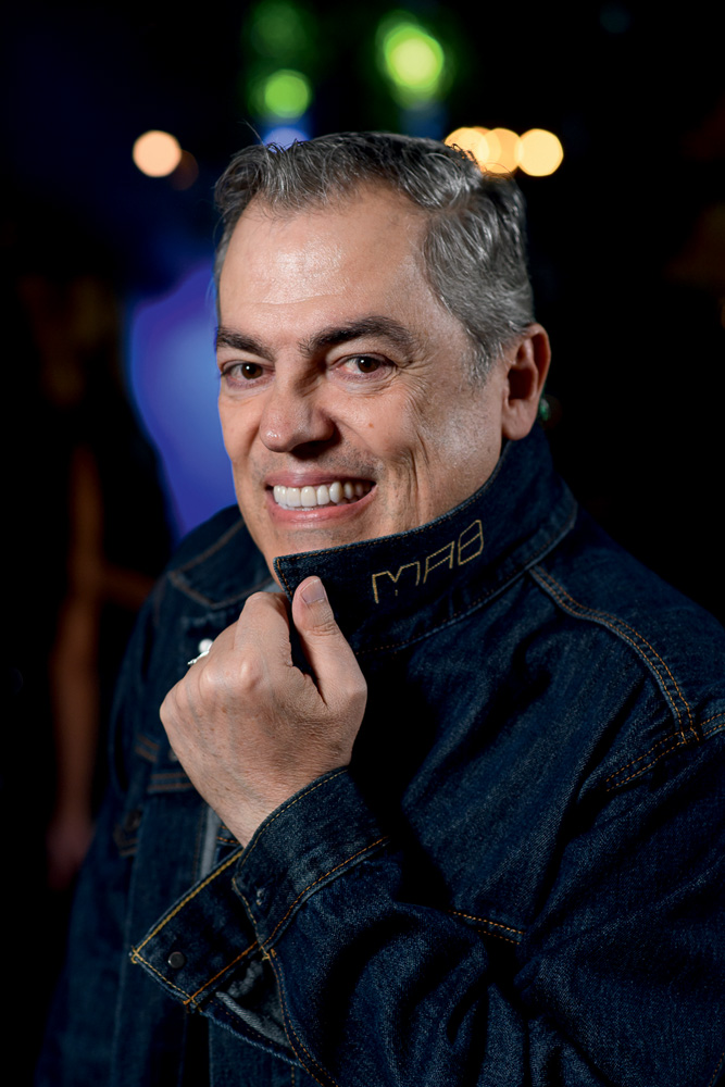 Marco Antonio Biaggi (Ângelo Pastorello-Divulgação).jpg Homem grisalho posa sorrindo e cobrindo o pescoço com a gola da jaqueta jeans escura.