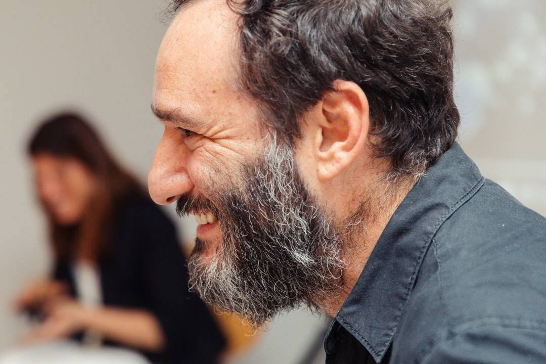 um homem branco de barba sorrindo