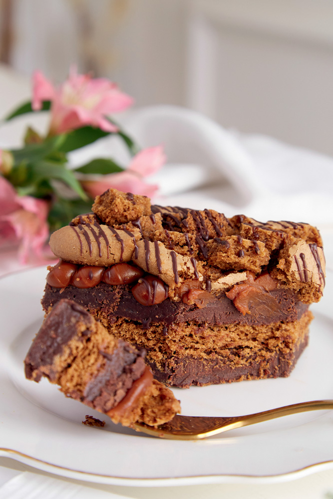 Bolo de massa marrom com duas camadas de ganache de chocolate.