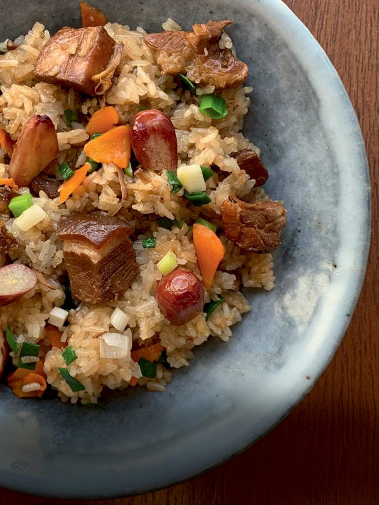 Butabara Okowa_Sozai Japanese Deli A imagem mostra um prato com arroz com pancetta visto de cima. Apenas metade do prato aparece.