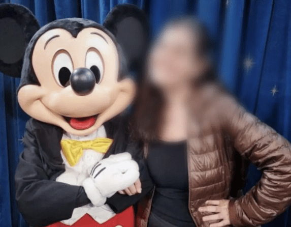 uma pessoa vestida de mickey abraçado a uma jovem