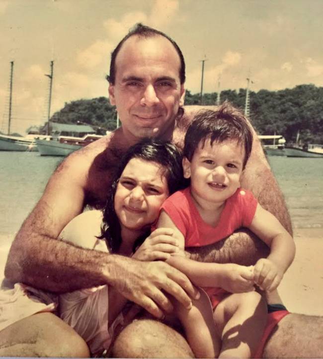 Família danemberg Foto antiga mostra Arnaldo abraçando os dois filhos, ainda crianças, em praia