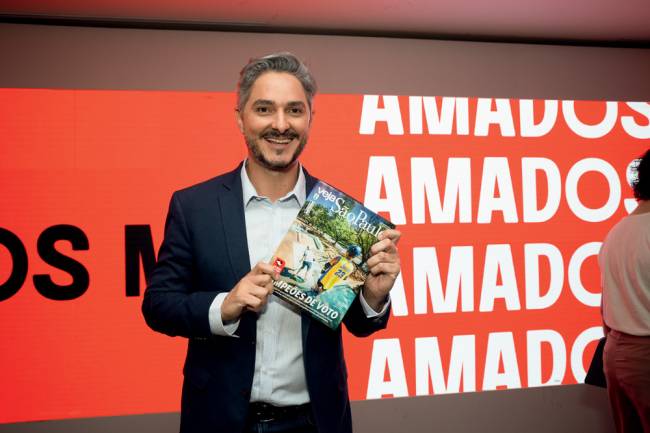 Imagem mostra homem segurando revista que mostra parque com crianças andando de skate