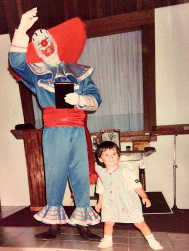 stacy locatelli e arlindo barreto bozo Foto antiga mostra Arlindo vestido como o palhaço Bozo e a filha, Stacy, pequena, sorrindo, com maquiagem de palhaça. Os dois estão na sala de uma casa