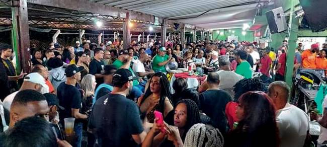cruz da esperança Imagem mostra ambiente fechado lotado com roda de samba ao fundo