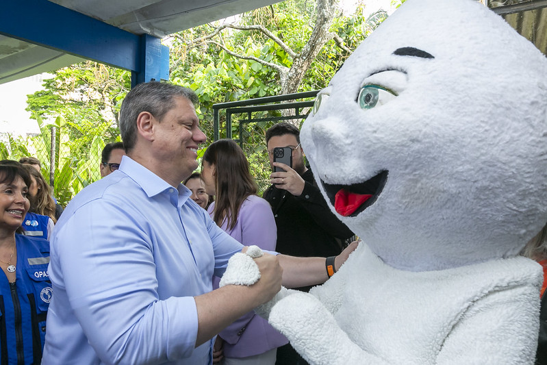O governador e o personagem Zé Gotinha se cumprimentando