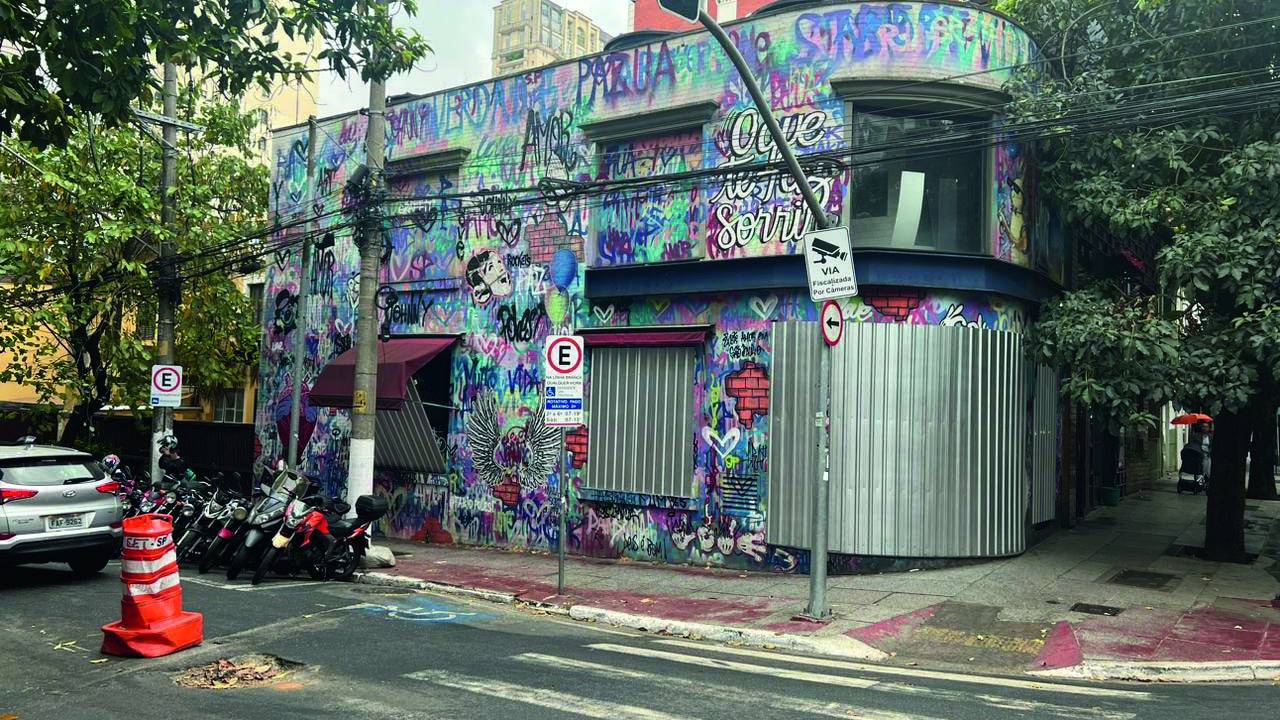 Foto de imóvel colorido de esquina com tapumes de metal.