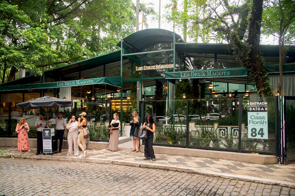 Fachada dos Les Deux Magots de vidro com estrutura metálica verde.