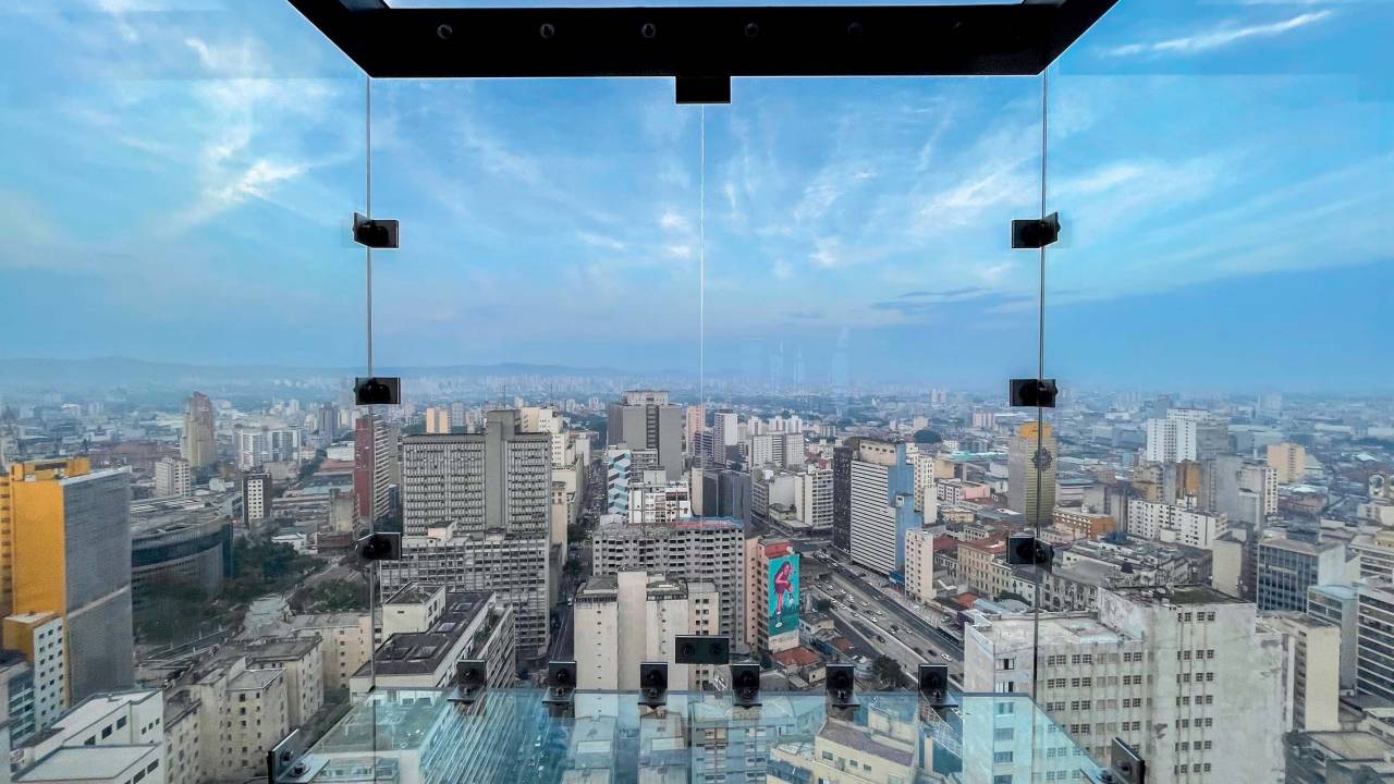 Quadrado de vidro exibe vista panorâmica da cidade.