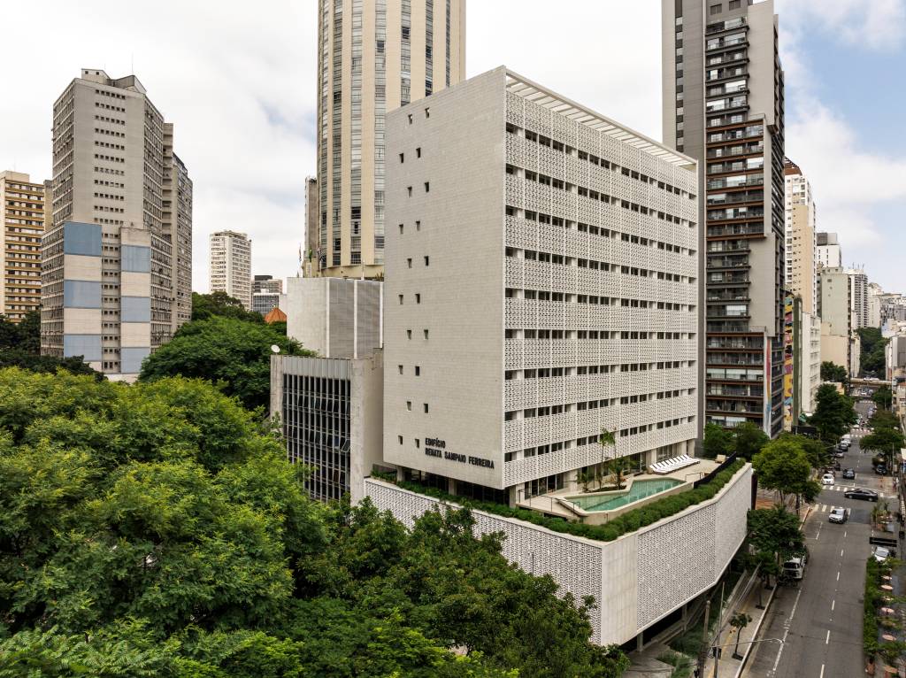 default Vista aérea de prédio branco com parede vazada em pequenos quadrados e piscina no terraço da área inferior