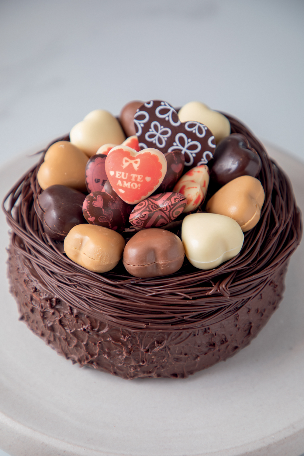 Confeitaria Dama cestinha de chocolate cheia e corações de chocolate de diferentes cores