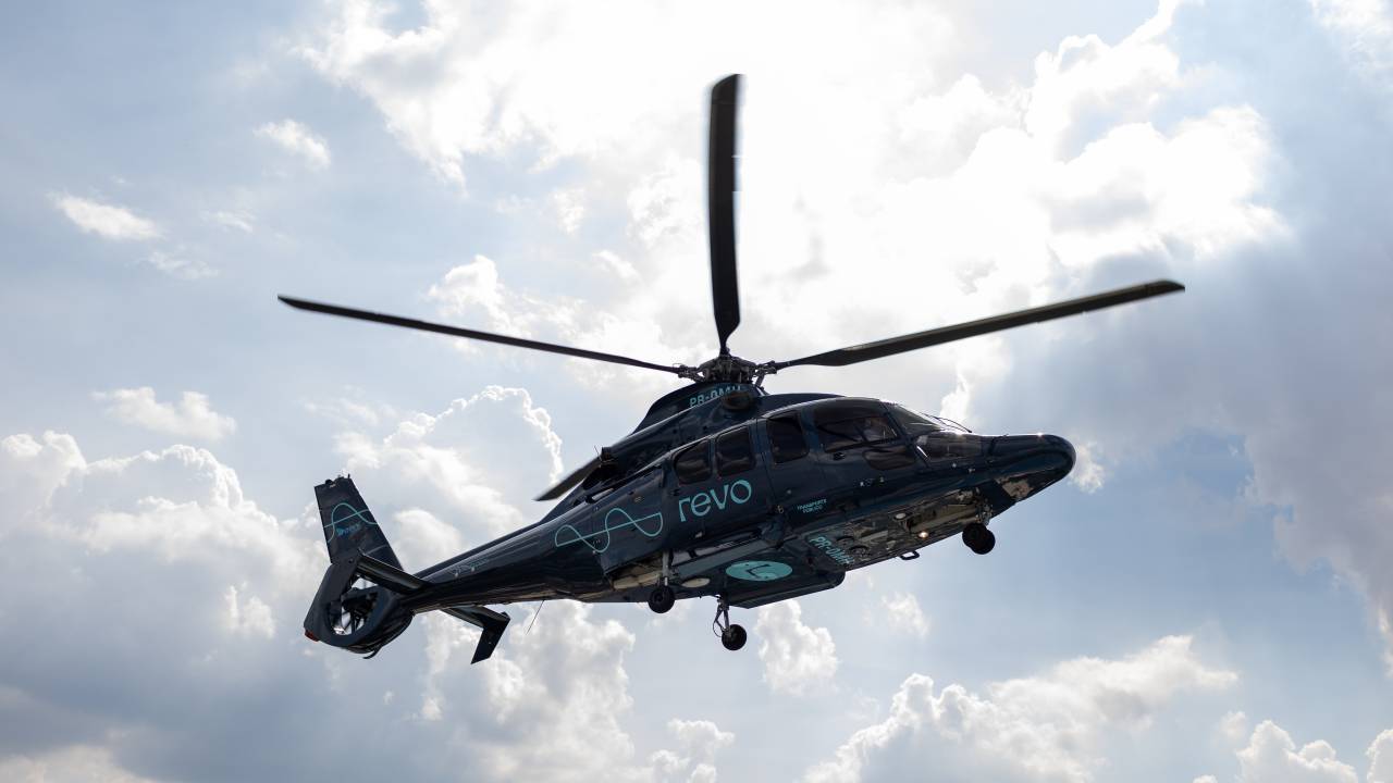 Foto de helicóptero no céu, apenas a silhueta.