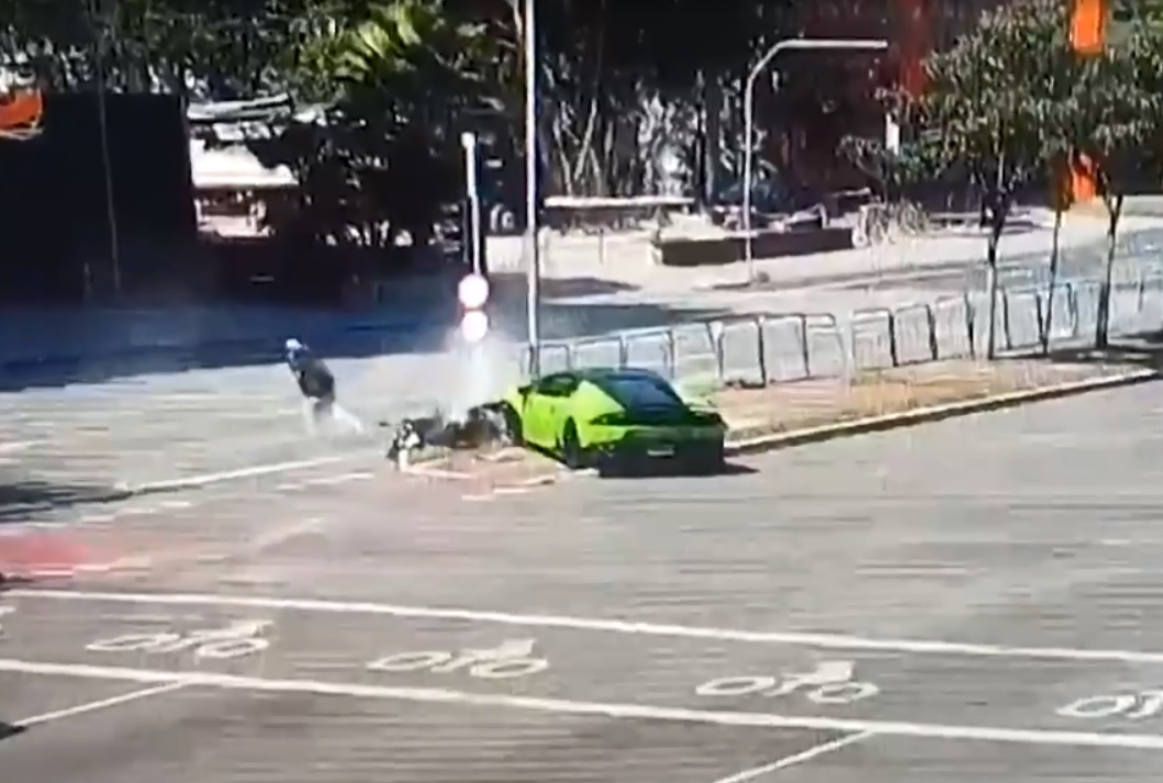 Foto mostra avenida com carro de luxo e poste caído