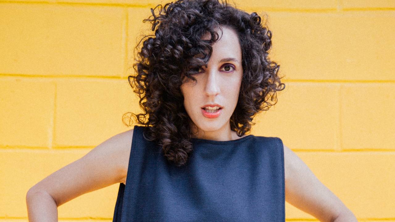 Moça branca de cabelos encaracolados vestindo vestido preto