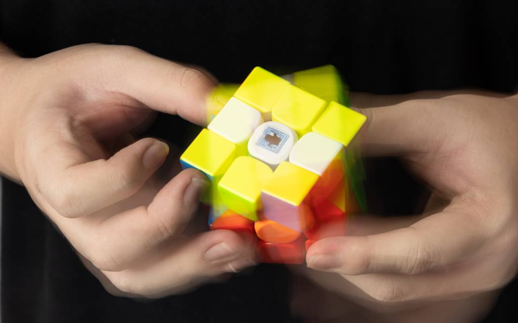 CUBOMAGICOCAIOSATO19 Foto de cubo mágico em movimento na mão de criança