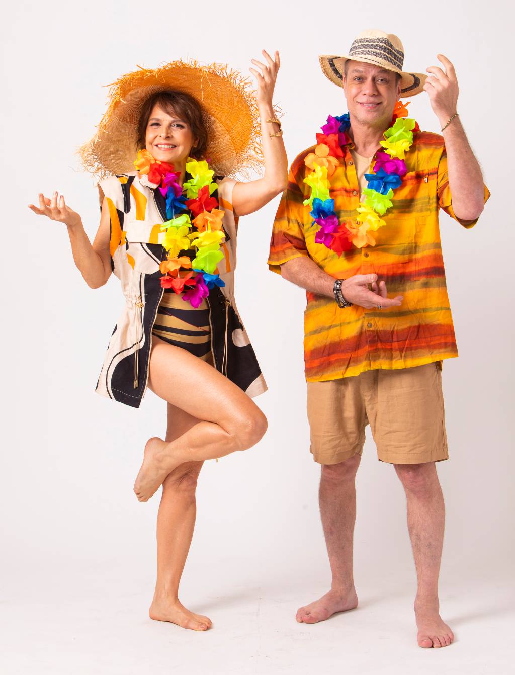 Foto: Leo Aversa Casal hétero branco posa com roupas de férias de praia, com colar colorido e chapéus