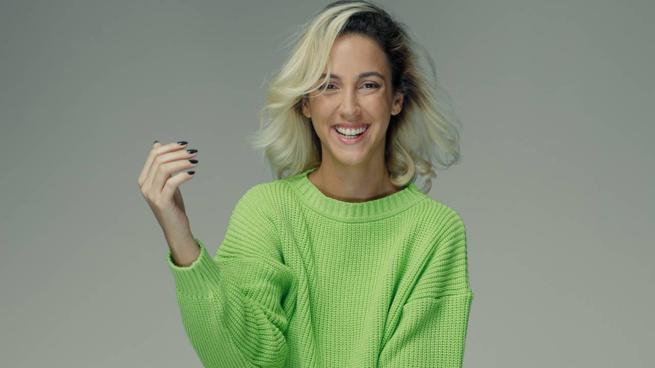 Mulher loira de suéter verde