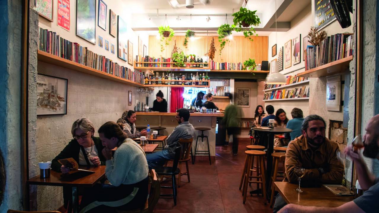Ambiente do bar com cadeiras e pessoas sentadas