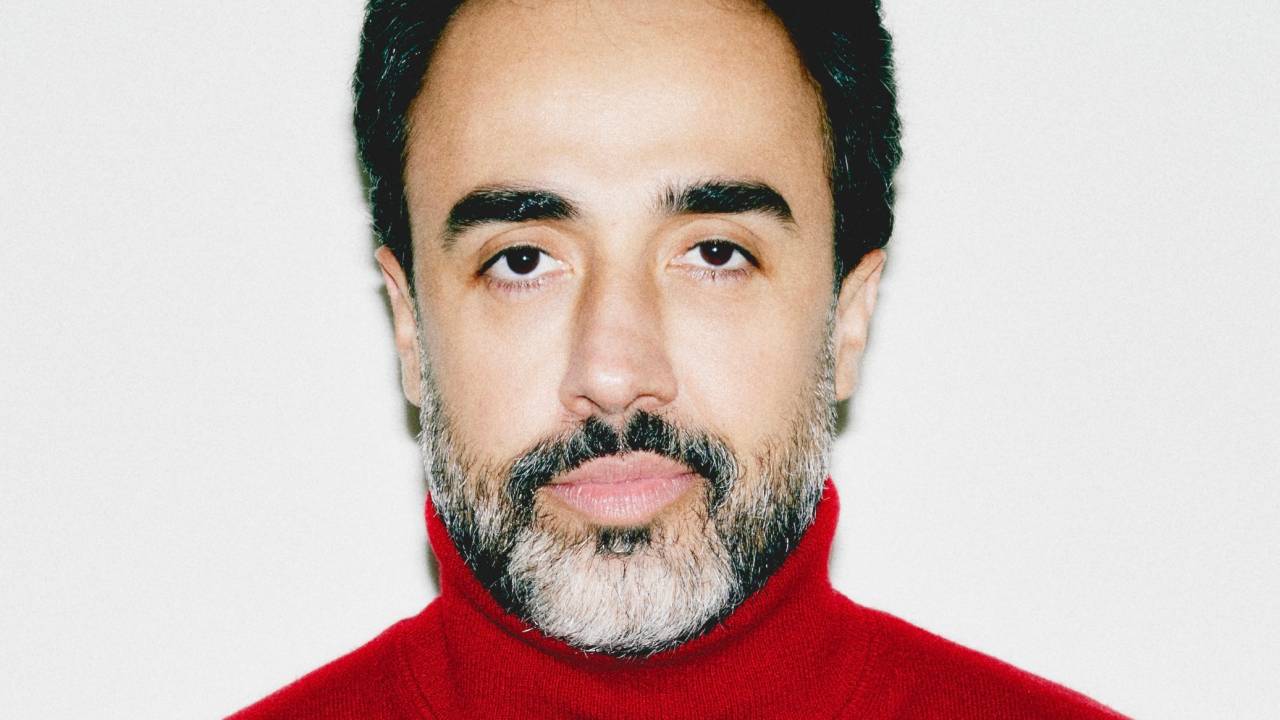 Homem de barba e suéter de gola alta vermelho
