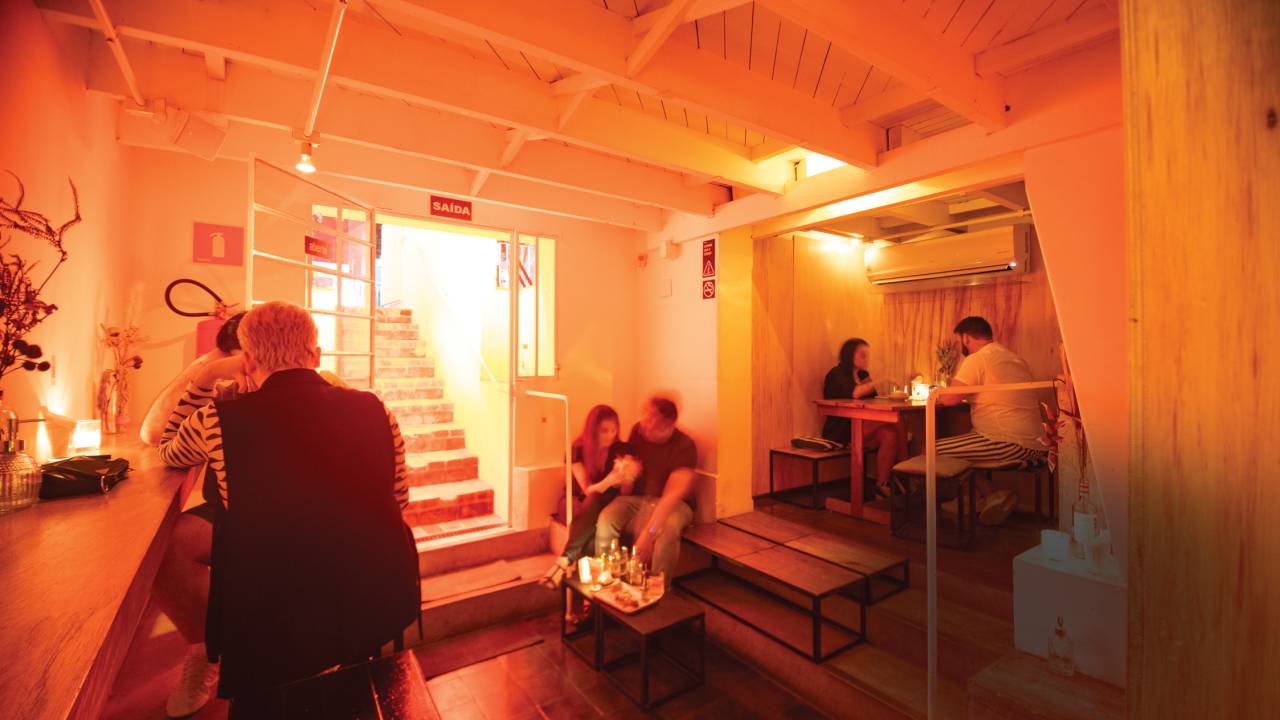 Ambiente interno do bar com mesas e cadeiras