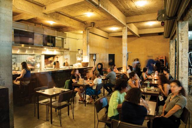 Atlântico 212 Salão do bar com pessoas sentadas na cadeiras e mesas