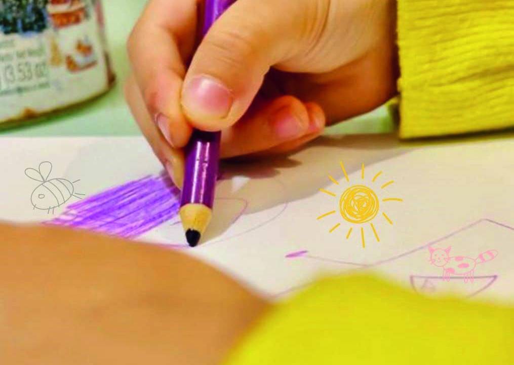 Criança desenhando com lápis roxo