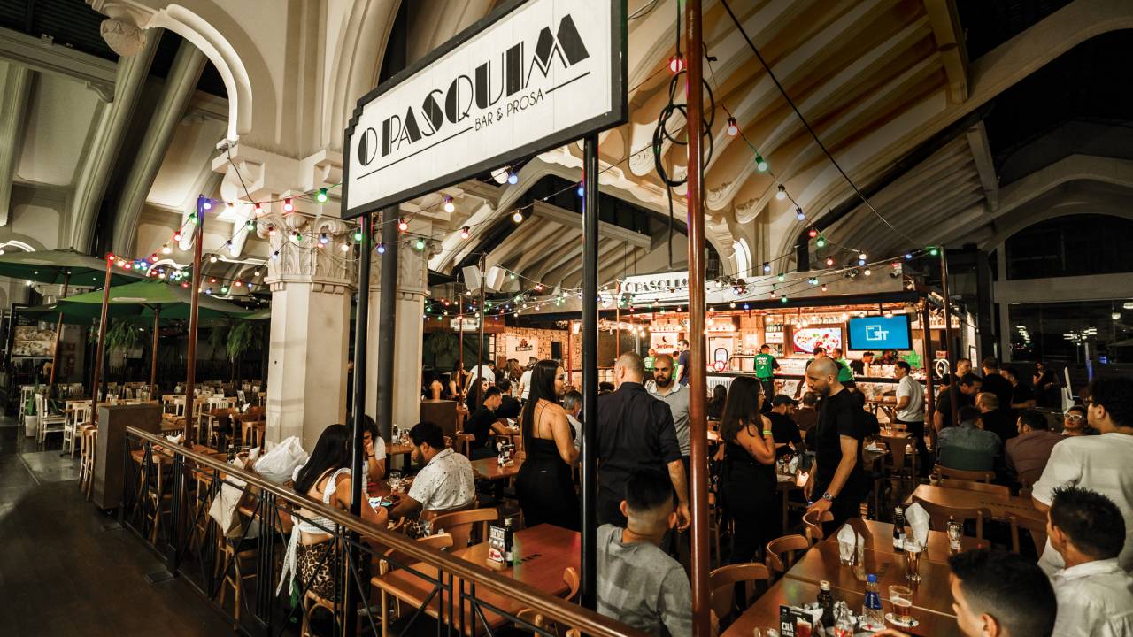 Frente do bar no mercadão com muitas pessoas nas mesas