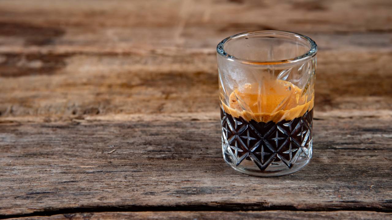 Copo transparente com café expresso e crema grossa marrom