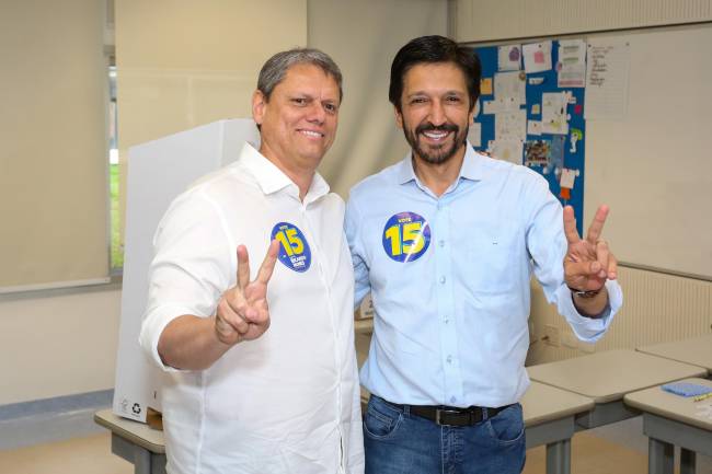 WhatsApp Image 2024-10-27 at 12.23.02 Duas pessoas sorrindo em sala de aula que acontece a votação