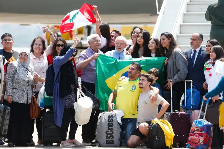 Pessoas segurando a bandeira do Brasil e sorrindo