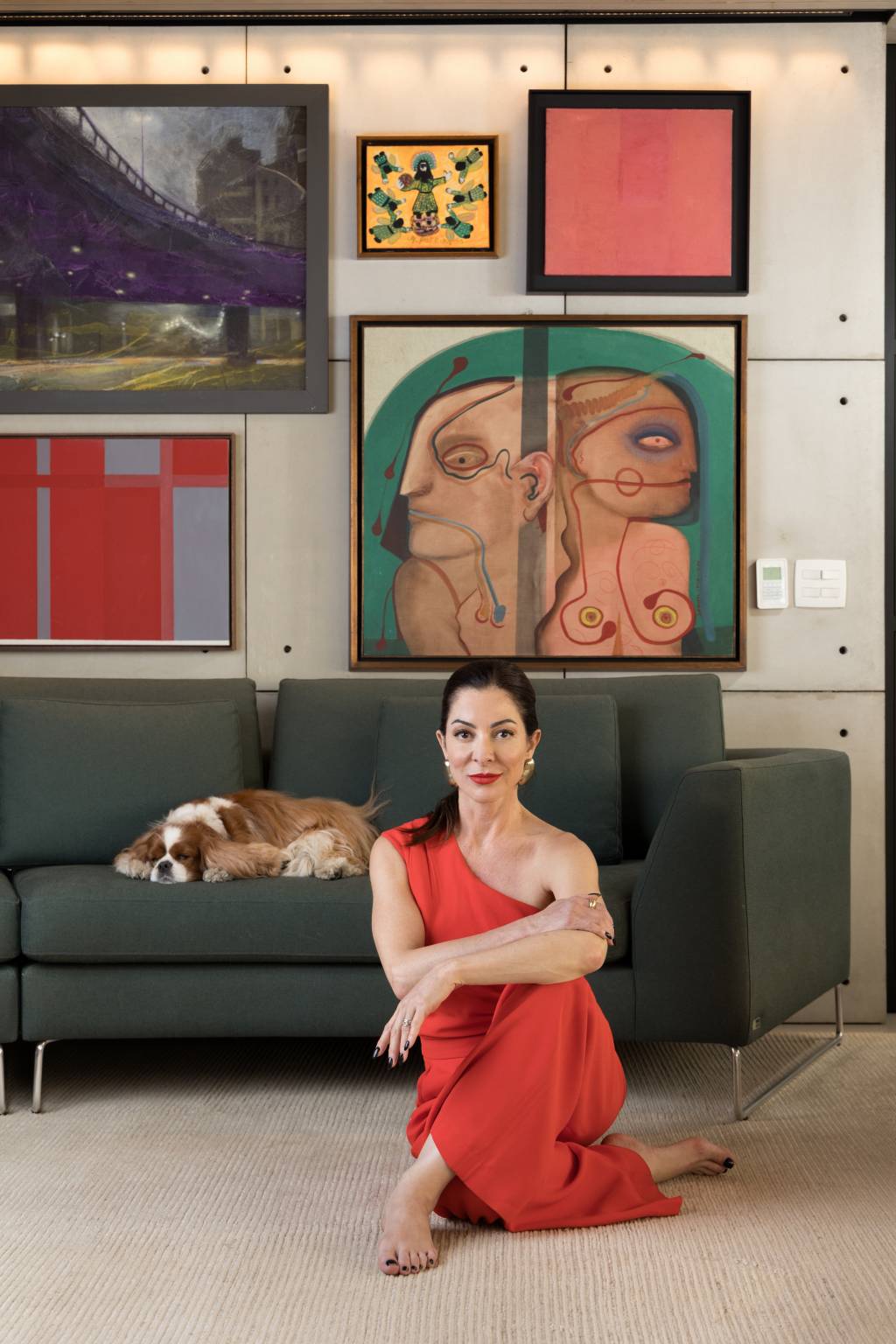 Ana Paula Padrão Crédito Wanezza Soares-VejaSP (05) Mulher branca de peça alaranjada posa no chão com sofá verde e cachorro ao fundo