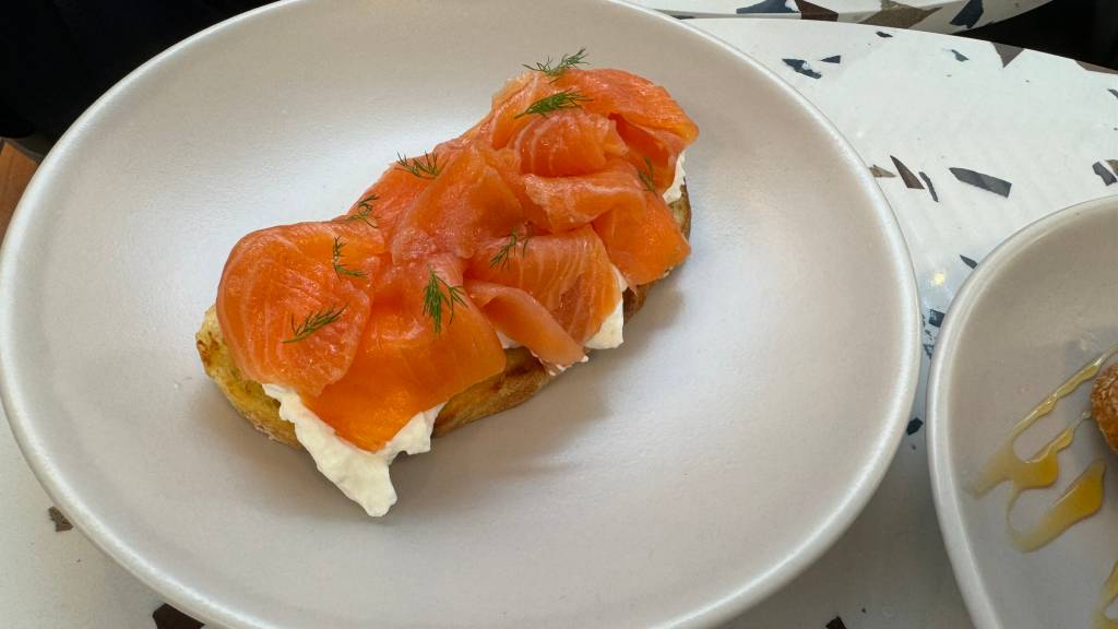 Tostada de salmão defumado, creme azedo e dill Fatia de pão torrado coberta por de salmão defumado, creme azedo e dill