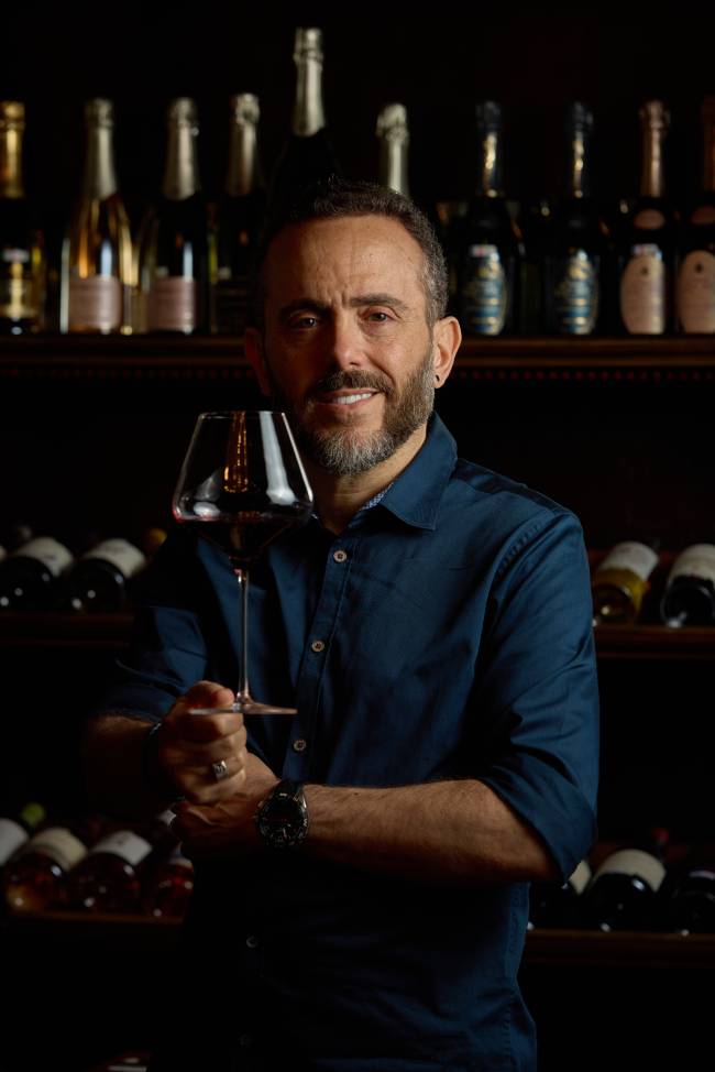 Isaac azar5 Homem segurando taça de vinho