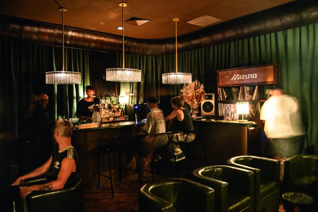 Lagrima Balcão com bebidas e poltrona e pouca luz
