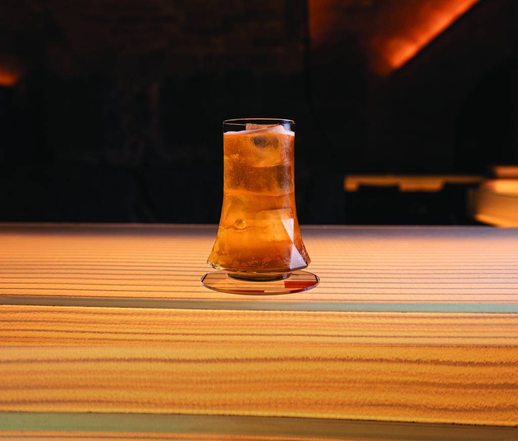Túnel(2) – Bar dos Arcos – Tati Frison_Divulgação.jpg Drinque laranja em cima de mesa de madeira