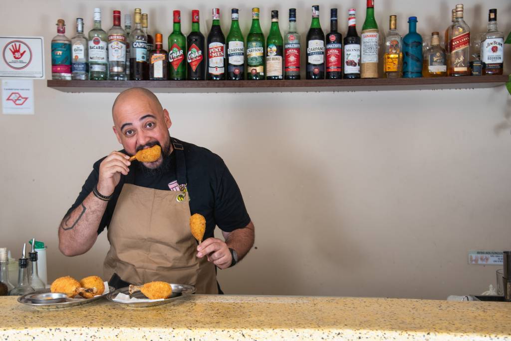Tantin Homem comendo coxinha com a mão