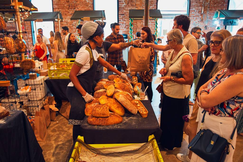 _AZ_5889 Pessoas circulando pela feira e pães na bancada