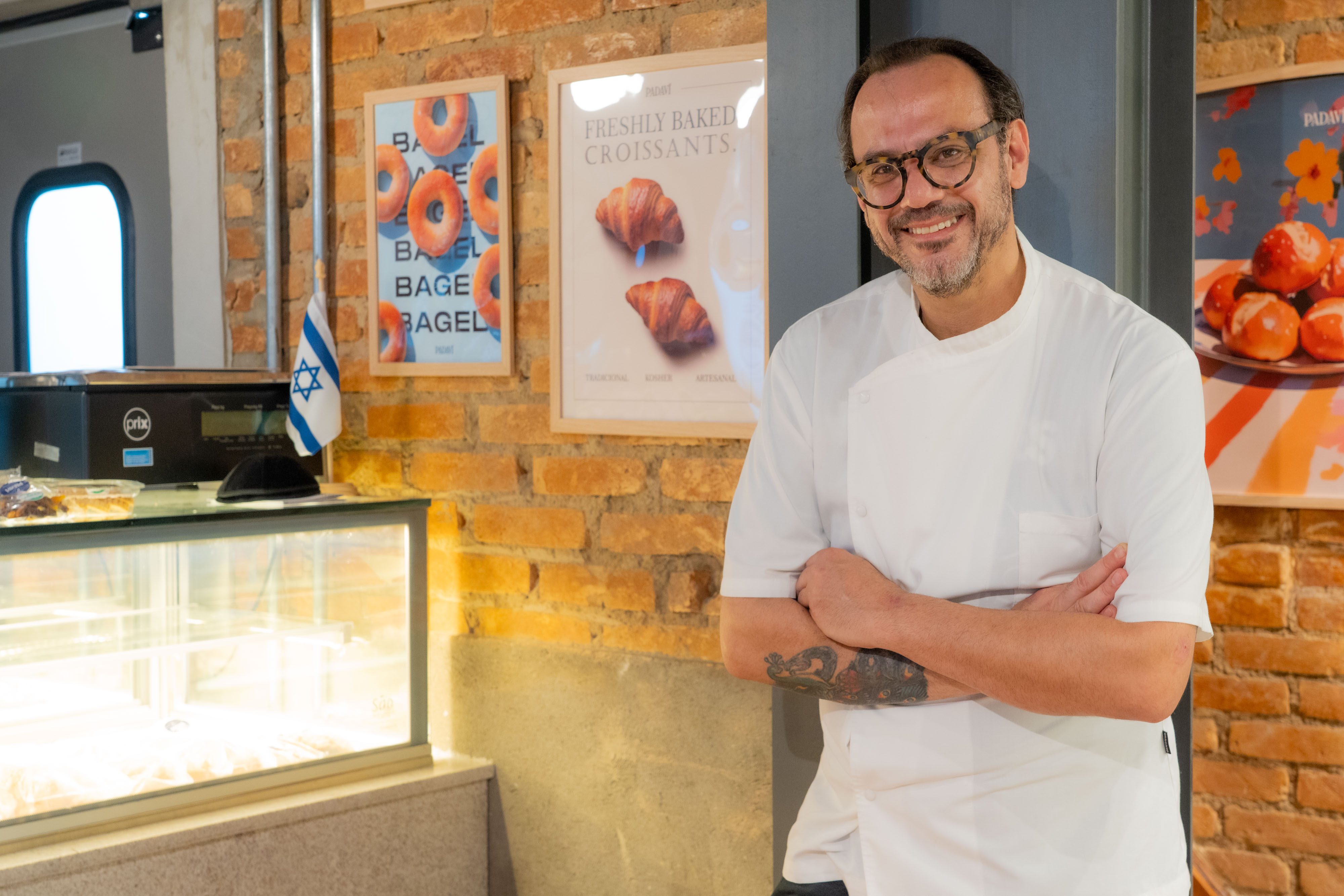 Homem sorrindo com bra&ccedil;os cruzados