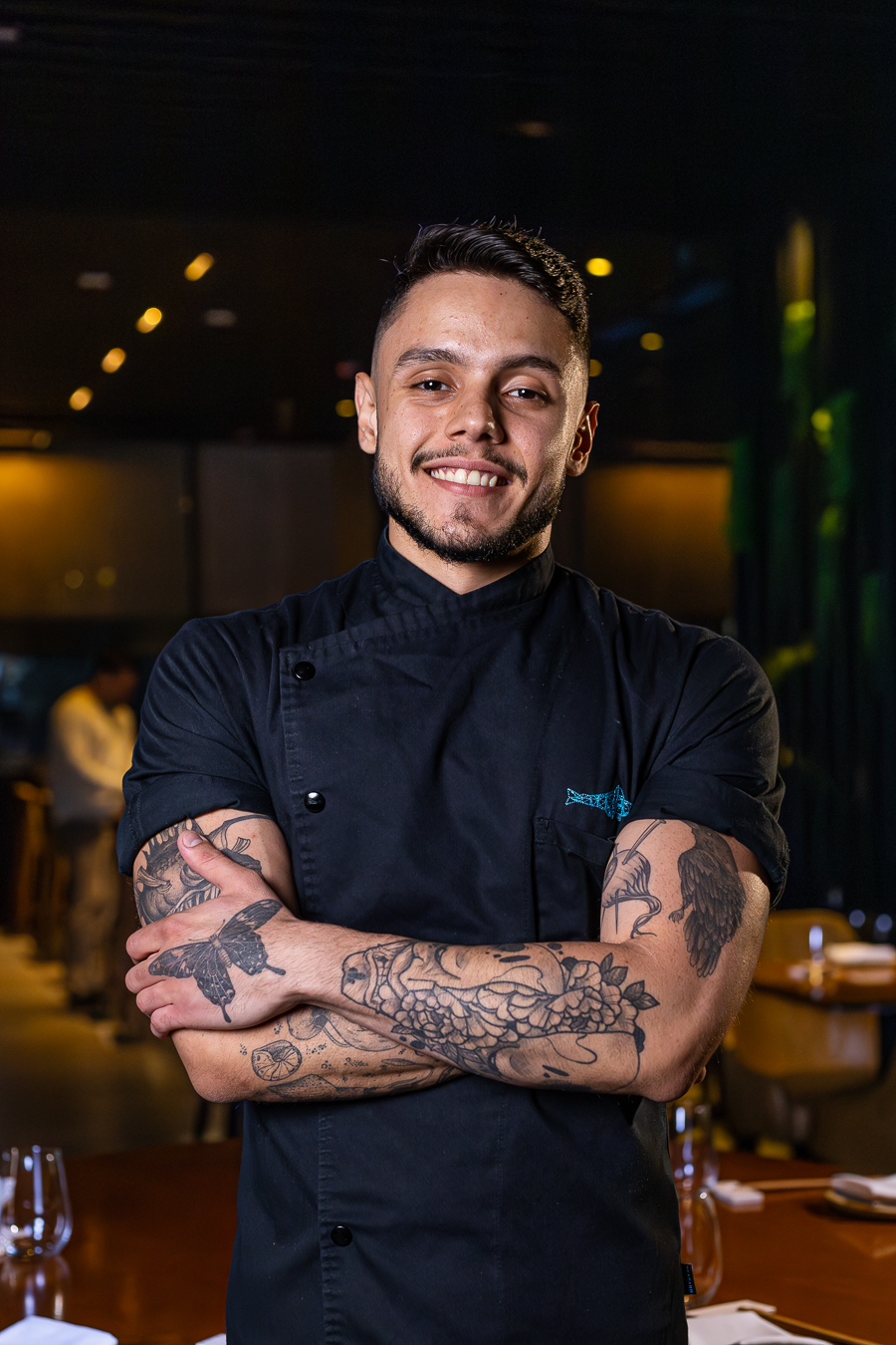 Homem sorrindo de bra&ccedil;o cruzado