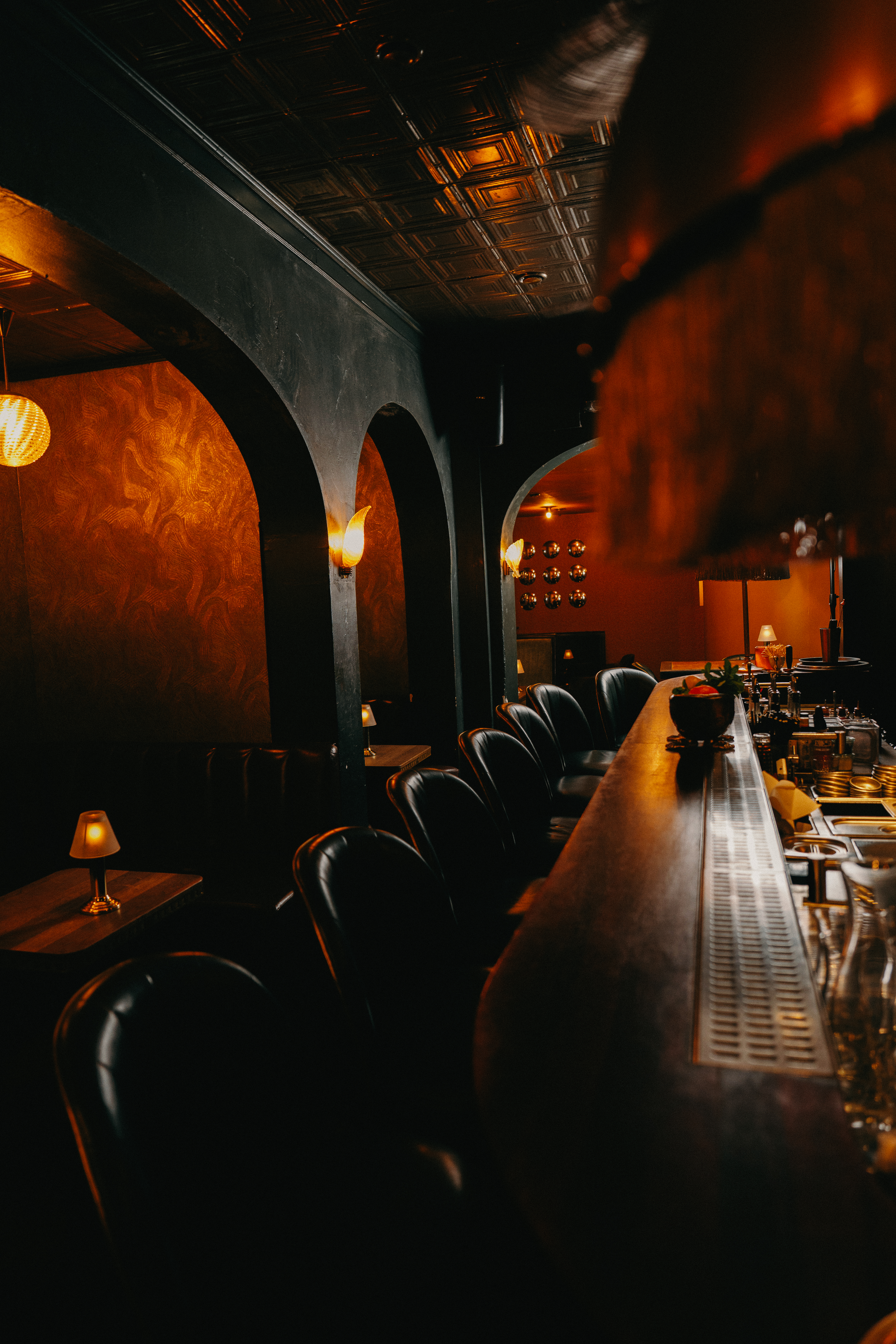 Foto de bar intimista com luz baixa e balc&atilde;o &agrave; direita