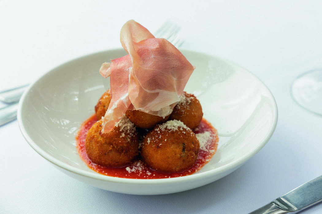 Prato branco com croquetas e presunto por cima